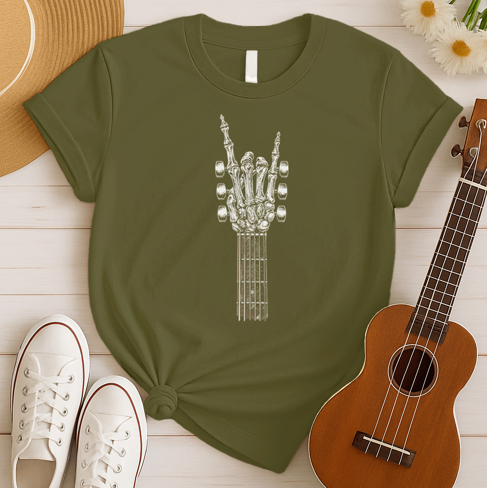 A bold graphic design depicts a skeletal hand forming the classic "rock and roll" sign, with the index and pinky fingers extended upwards, and the thumb holding down the middle two fingers. The hand, rendered in a detailed bone-like texture with shades of white and gray, is positioned at the top of a guitar fretboard, which features brown and white frets and tuning pegs on either side. This powerful image symbolizes the enduring spirit of rock music and its connection to the eternal nature of this genre.
