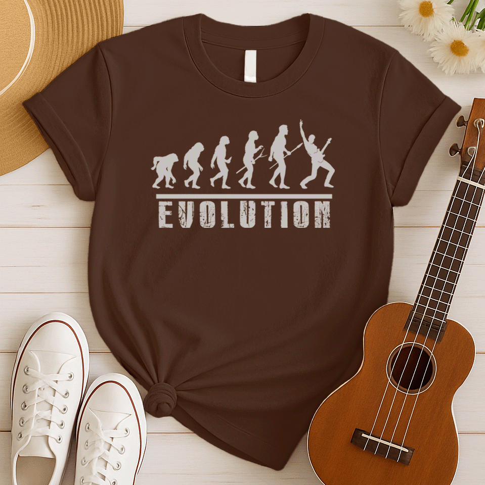 A striking graphic design illustrates the "Evolution of Man" in a sequence of white silhouettes against a black background, beginning with an ape-like figure and progressing through various stages of hominid development. The final figure in the evolutionary chain is a modern human, dynamically playing an electric guitar and raising a "rock on" hand gesture, symbolizing the evolution into a "rockstar." Below the figures, the bold, distressed white word "EVOLUTION" is prominently displayed.