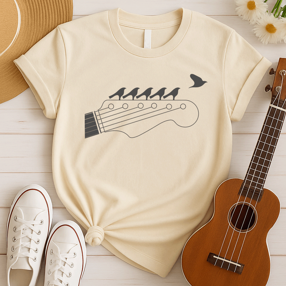 Stylized black graphic of a guitar headstock with tuning pegs and strings. Five small birds are perched in silhouette on the guitar strings, and one bird is depicted flying away in the top right corner. The design suggests musical harmony, freedom, and a connection between nature and guitar music. Ideal for guitar enthusiasts and musicians.