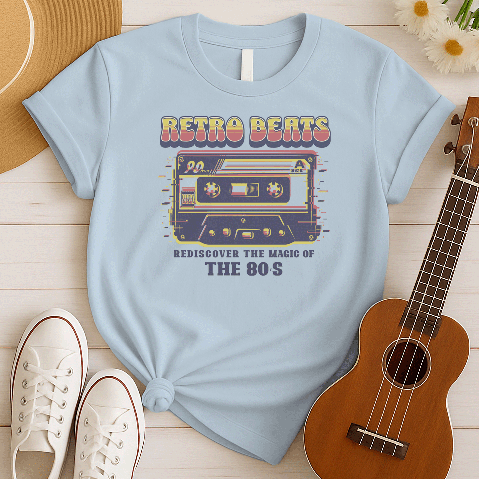 Stylized graphic of a classic audio cassette tape in red, yellow, and blue colors with a glitch effect. Large, distressed orange text above reads "RETRO BEATS". Smaller orange text below reads "REDISCOVER THE MAGIC OF THE 80S". The design evokes vintage music, 80s pop culture, and retro audio technology. Ideal for 80s enthusiasts and music lovers.