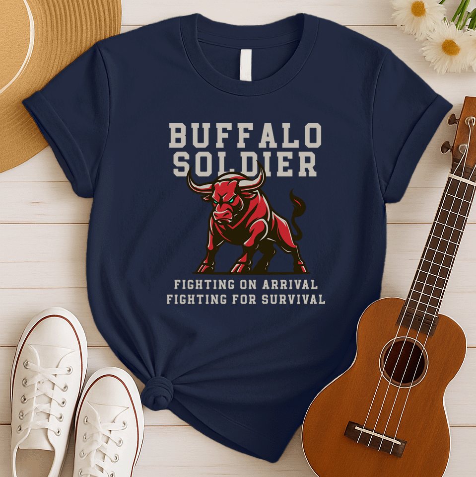 A striking graphic design features a powerfully built red bull with menacing green eyes and prominent horns, depicted in a charging or aggressive stance. The bull's body is outlined in a lighter shade of red, giving it depth. Above the bull, the words "BUFFALO SOLDIER" are written in bold, athletic-style block letters, with "BUFFALO" in white and "SOLDIER" in light grey. Below the bull, two lines of text read "FIGHTING ON ARRIVAL" and "FIGHTING FOR SURVIVAL," both in white, bold, block letters.