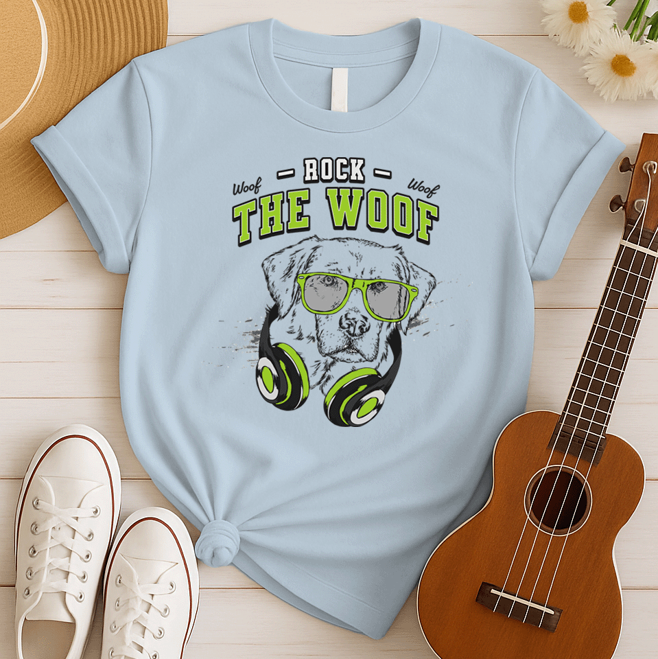 Graphic of a black dog's head wearing bright green-rimmed sunglasses and large headphones with green accents. White distressed text above reads "ROCK" and below the dog's head, large green text with a black outline reads "THE WOOF". Smaller "Woof" texts are on either side of "ROCK". The design suggests rock music, dog lovers, and a cool animal DJ aesthetic. Ideal for pet owners and music enthusiasts.