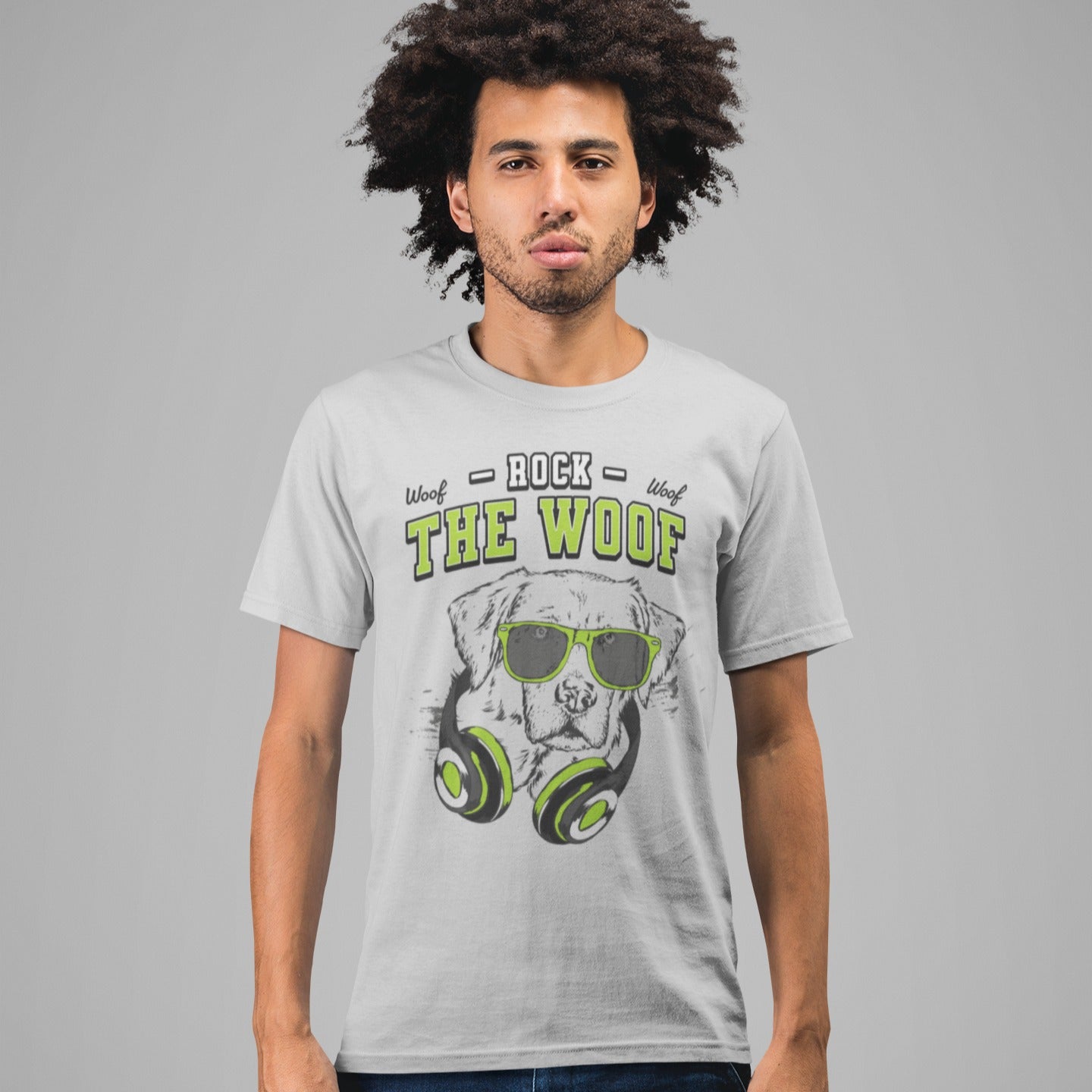 Graphic of a black dog's head wearing bright green-rimmed sunglasses and large headphones with green accents. White distressed text above reads "ROCK" and below the dog's head, large green text with a black outline reads "THE WOOF". Smaller "Woof" texts are on either side of "ROCK". The design suggests rock music, dog lovers, and a cool animal DJ aesthetic. Ideal for pet owners and music enthusiasts.