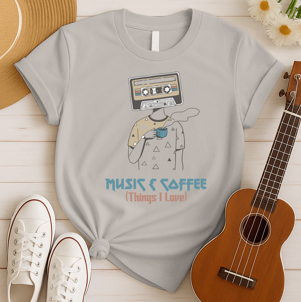 Stylized graphic of a person's body with a vintage brown and black audio cassette tape as its head, holding a blue steaming coffee cup. Small triangle patterns are on the person's beige shirt. Blue distressed text below reads "MUSIC & COFFEE" and red text below that says "(Things I Love)". The design embodies music appreciation, coffee love, and retro nostalgia, ideal for music lovers and coffee enthusiasts.