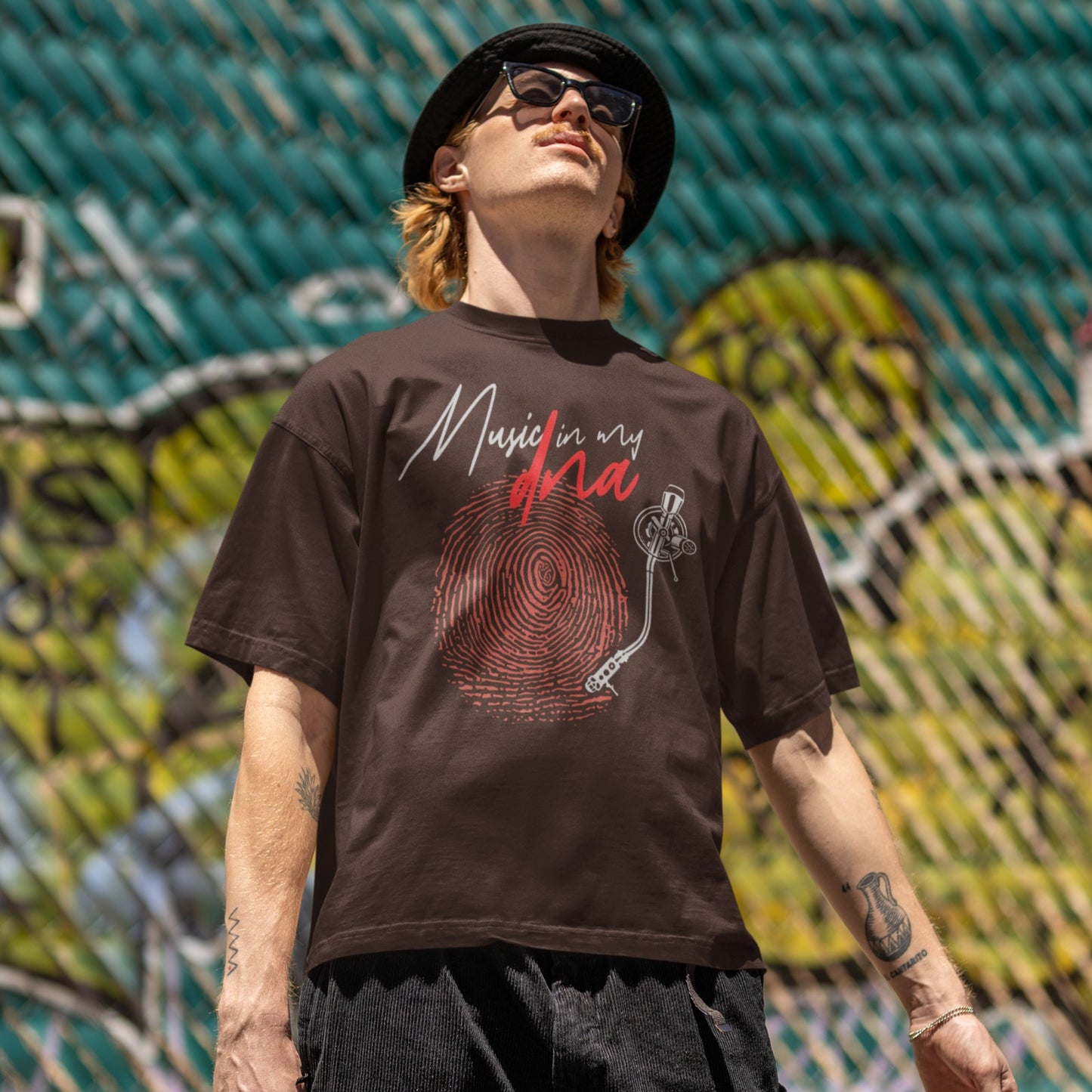Stylized graphic of a large red fingerprint that is designed like the grooves of a vinyl record, with a white turntable tonearm and needle positioned on it. Above, white handwritten text says "Music in my" and red stylized text says "dna". The design perfectly symbolizes an inherent passion for music, vinyl records, and unique identity, ideal for music lovers and DJs.