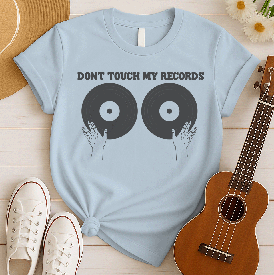 A black background features the bold, capitalized text "DONT TOUCH MY RECORDS" at the top. Below, two large, dark grey vinyl records are depicted side-by-side, with two outlined hands reaching up from the bottom, appearing to cup or touch the records. The design is humorous, symbolizing a possessive love for music, vinyl records, and record collecting, ideal for audiophiles and music fans.