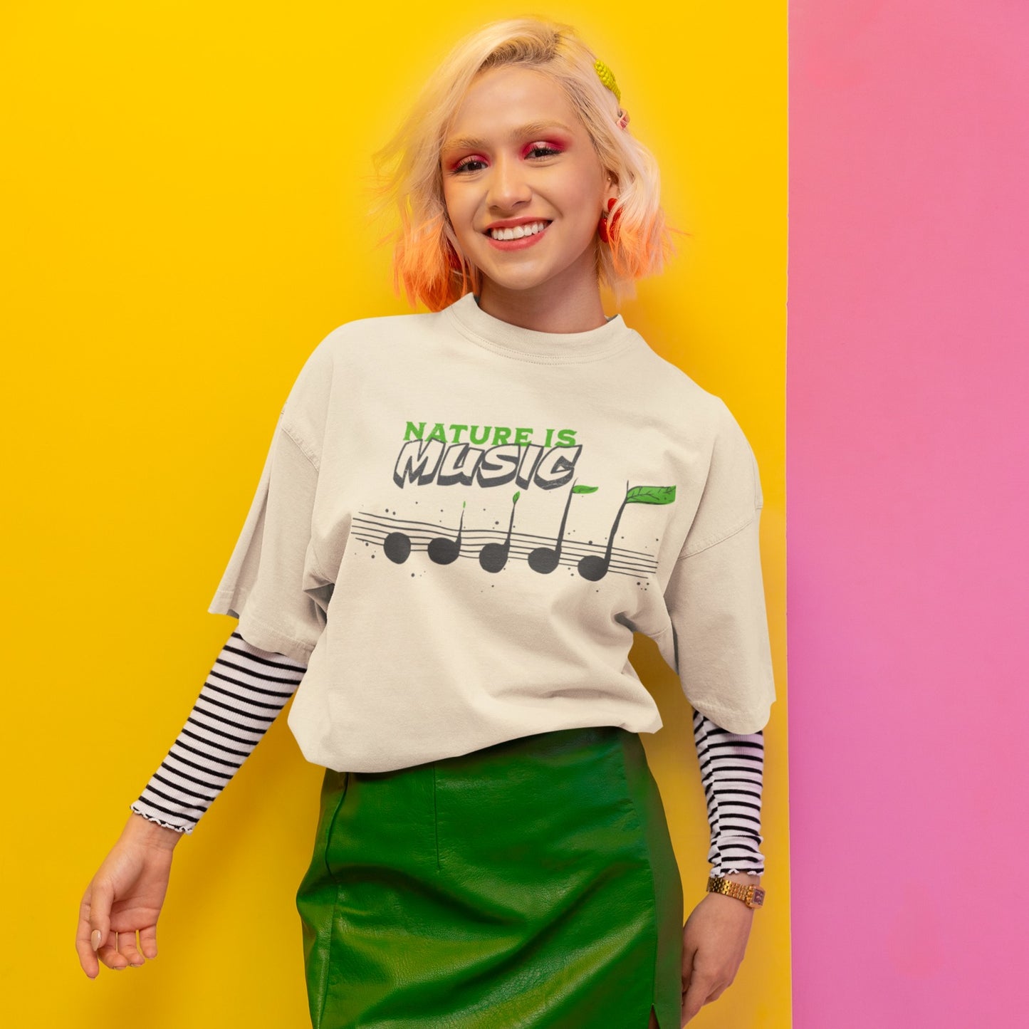 A tshirt design features the text "NATURE IS" in a distressed green font at the top. Below it, the word "MUSIC" is prominently displayed in a larger, distressed dark grey font with a subtle 3D effect. Below the text, a horizontal musical staff is shown with five round, dark grey quarter notes. Each note has a small green leaf growing from its stem, with the last note having a larger, more prominent green leaf. The design symbolizes the connection between nature and music, perfect for environmentalists an