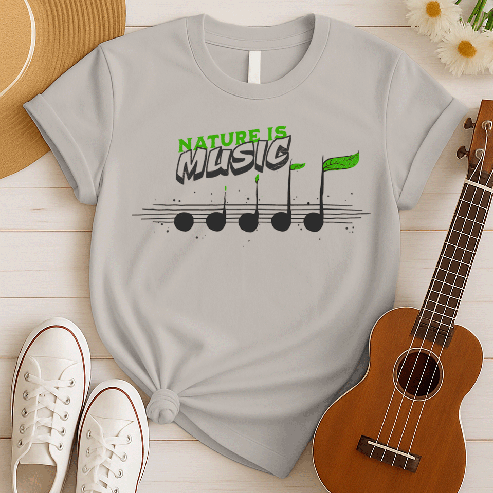 A tshirt design features the text "NATURE IS" in a distressed green font at the top. Below it, the word "MUSIC" is prominently displayed in a larger, distressed dark grey font with a subtle 3D effect. Below the text, a horizontal musical staff is shown with five round, dark grey quarter notes. Each note has a small green leaf growing from its stem, with the last note having a larger, more prominent green leaf. The design symbolizes the connection between nature and music, perfect for environmentalists an