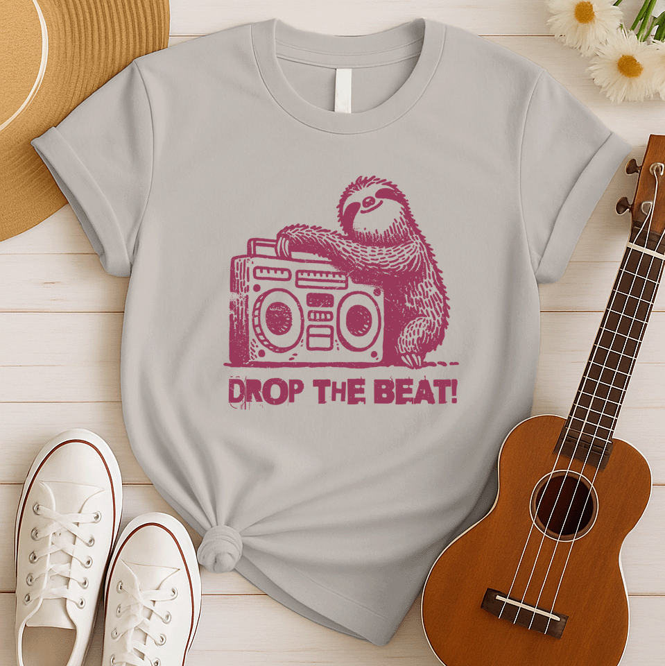 A light grey background features a distressed, red-brown illustration of a fluffy sloth. The sloth is leaning on a large, matching red-brown boombox, which has prominent speakers and controls. Below the sloth and boombox, the distressed text "DROP THE BEAT!" is written in a blocky, red-brown font with a slight splattered effect. The design portrays a relaxed animal enjoying loud music from a retro radio.