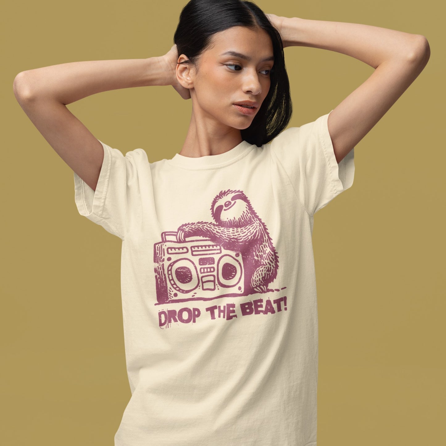 A light grey background features a distressed, red-brown illustration of a fluffy sloth. The sloth is leaning on a large, matching red-brown boombox, which has prominent speakers and controls. Below the sloth and boombox, the distressed text "DROP THE BEAT!" is written in a blocky, red-brown font with a slight splattered effect. The design portrays a relaxed animal enjoying loud music from a retro radio.