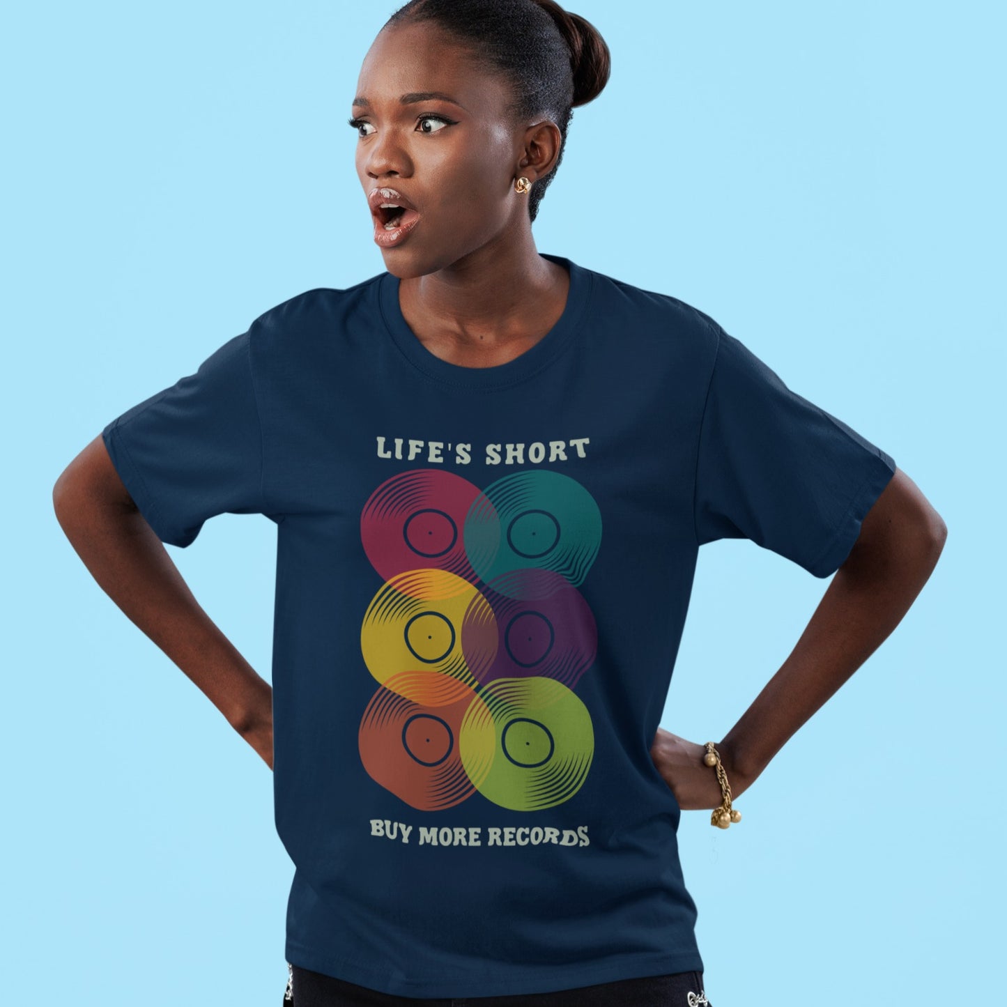 A black background features six vertically stacked, colorful vinyl records (LP records) with visible grooves and black center labels. The record colors include red, teal, yellow, purple, orange, and green. At the top, the distressed text "LIFE'S SHORT" is present, and at the bottom, the distressed text "BUY MORE RECORDS" is visible. The design is a clear celebration of vinyl culture and music collecting.