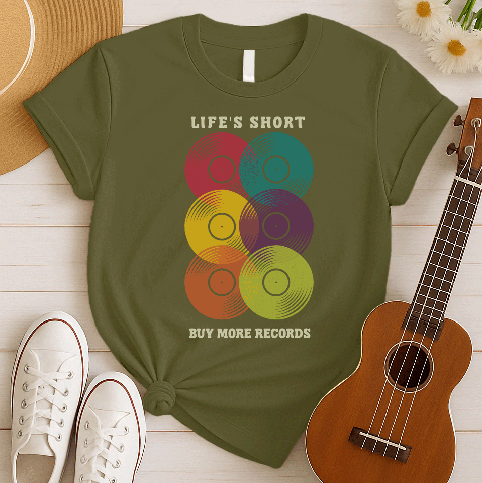 A black background features six vertically stacked, colorful vinyl records (LP records) with visible grooves and black center labels. The record colors include red, teal, yellow, purple, orange, and green. At the top, the distressed text "LIFE'S SHORT" is present, and at the bottom, the distressed text "BUY MORE RECORDS" is visible. The design is a clear celebration of vinyl culture and music collecting.