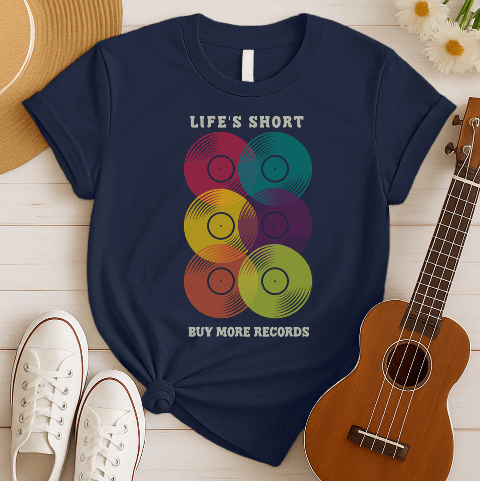 A black background features six vertically stacked, colorful vinyl records (LP records) with visible grooves and black center labels. The record colors include red, teal, yellow, purple, orange, and green. At the top, the distressed text "LIFE'S SHORT" is present, and at the bottom, the distressed text "BUY MORE RECORDS" is visible. The design is a clear celebration of vinyl culture and music collecting.