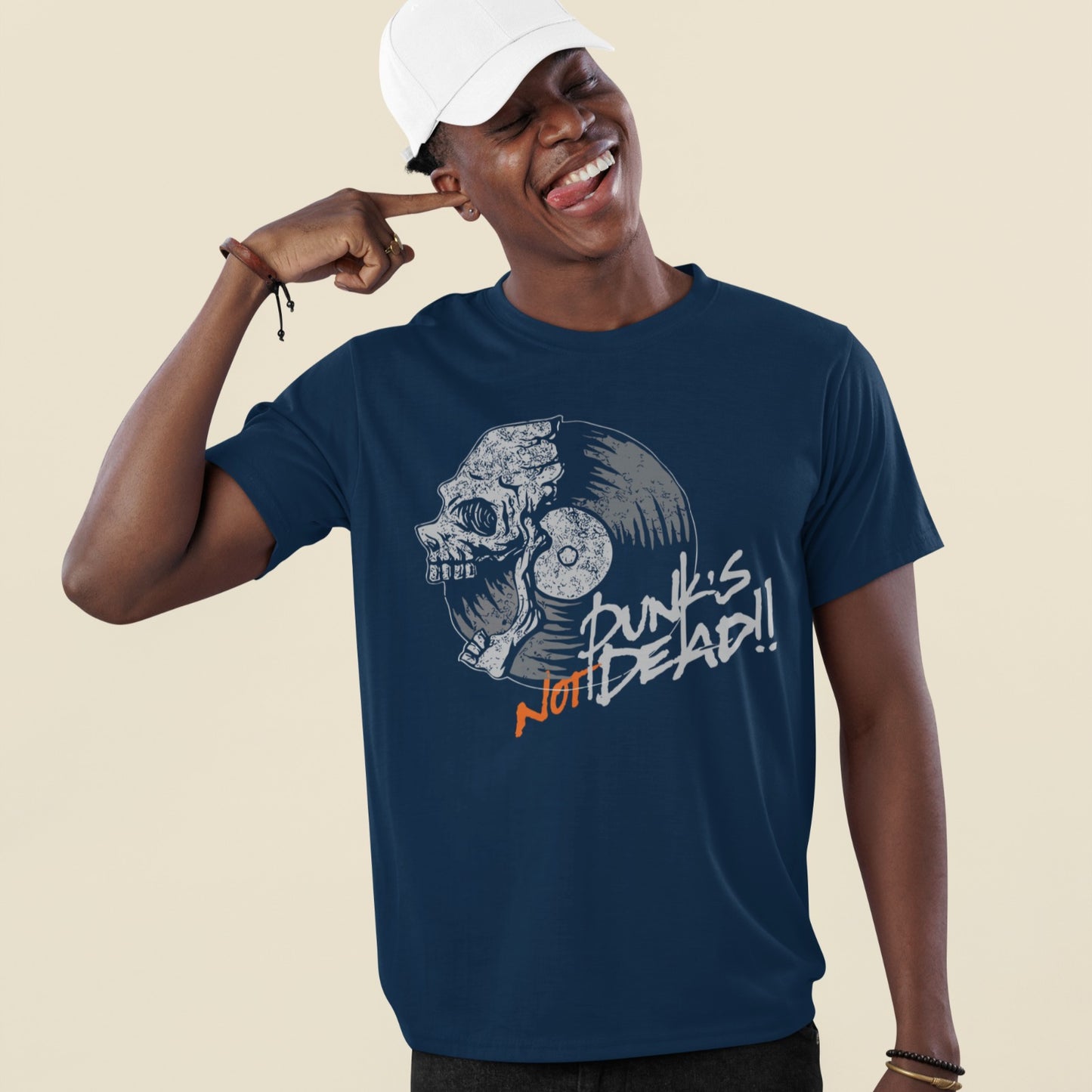 A black background features a stylized illustration of a grey human skull with a crack on its forehead, fused with a vinyl record. The record's grooves and central light grey area are visible. To the right, the distressed grey text reads "Punk's", followed by distressed white text "Not Dead!!". Below this, the orange distressed text "NOT DEAD!!" provides emphasis. The design combines punk music themes with skull imagery and vinyl records.