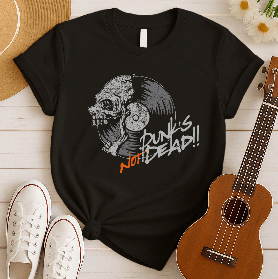 A black background features a stylized illustration of a grey human skull with a crack on its forehead, fused with a vinyl record. The record's grooves and central light grey area are visible. To the right, the distressed grey text reads "Punk's", followed by distressed white text "Not Dead!!". Below this, the orange distressed text "NOT DEAD!!" provides emphasis. The design combines punk music themes with skull imagery and vinyl records.