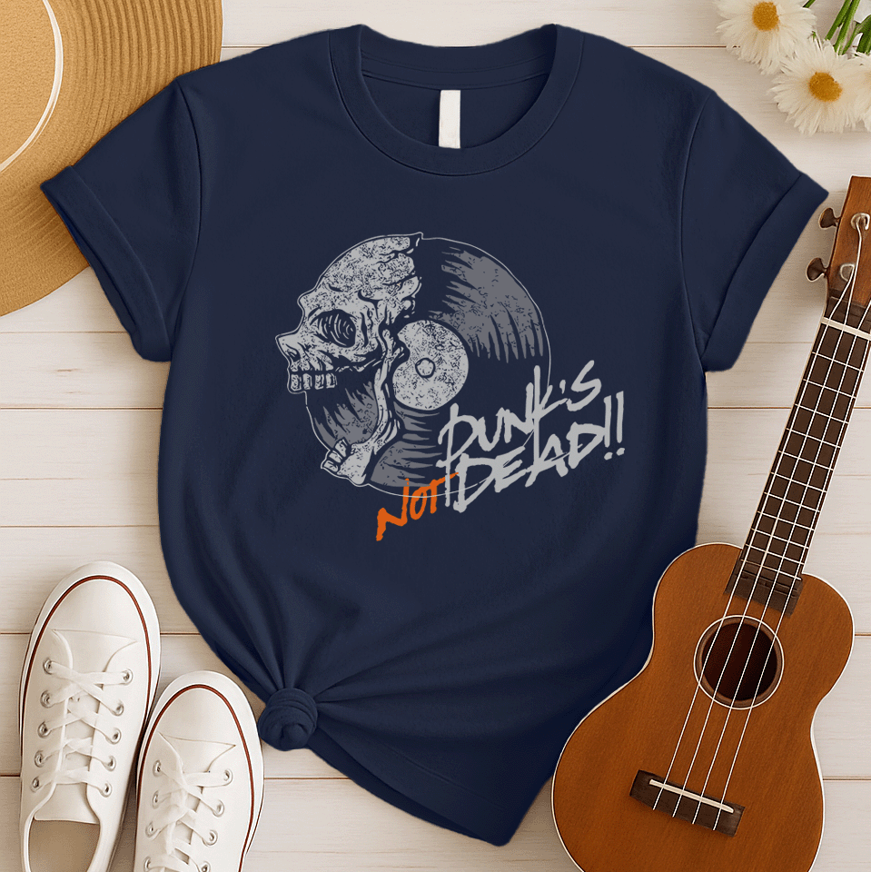 A black background features a stylized illustration of a grey human skull with a crack on its forehead, fused with a vinyl record. The record's grooves and central light grey area are visible. To the right, the distressed grey text reads "Punk's", followed by distressed white text "Not Dead!!". Below this, the orange distressed text "NOT DEAD!!" provides emphasis. The design combines punk music themes with skull imagery and vinyl records.
