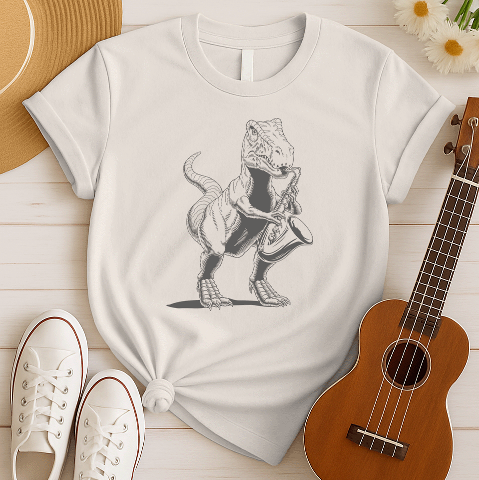 A powerful graphic design depicts a dark grey Tyrannosaurus Rex (T-Rex) holding and seemingly playing a saxophone. The T-Rex is detailed with scales and a strong posture, clutching the saxophone in its small but capable forelimbs. The musical instrument is rendered in a slightly lighter shade of grey, showcasing its keys and bell. This unique illustration, humorously blends prehistoric might with the smooth sounds of jazz or blues.