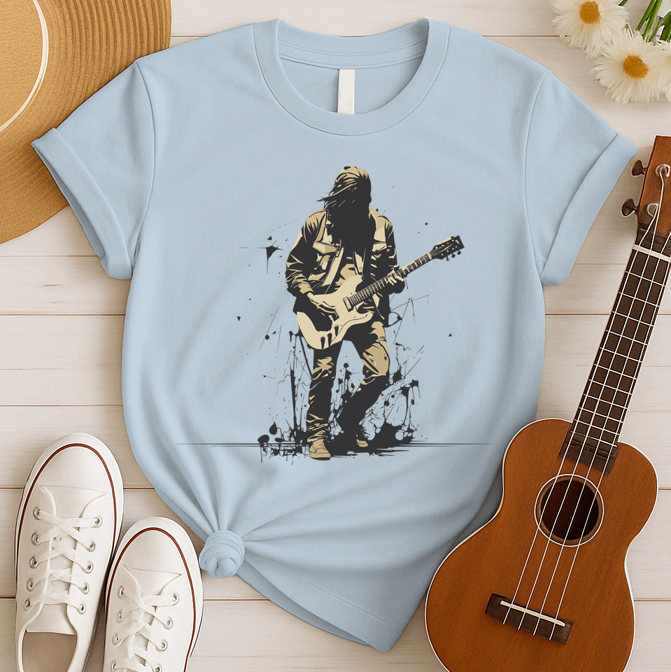 A striking graphic design depicts a silhouetted rock musician, with dark, flowing hair and a black outline, intensely playing a light beige electric guitar. The musician wears a detailed beige jacket and pants, with their form subtly highlighted against the darker background. Splatters of black paint or ink are visible around the musician's feet, adding a raw, energetic, and slightly rebellious aesthetic to the overall composition.