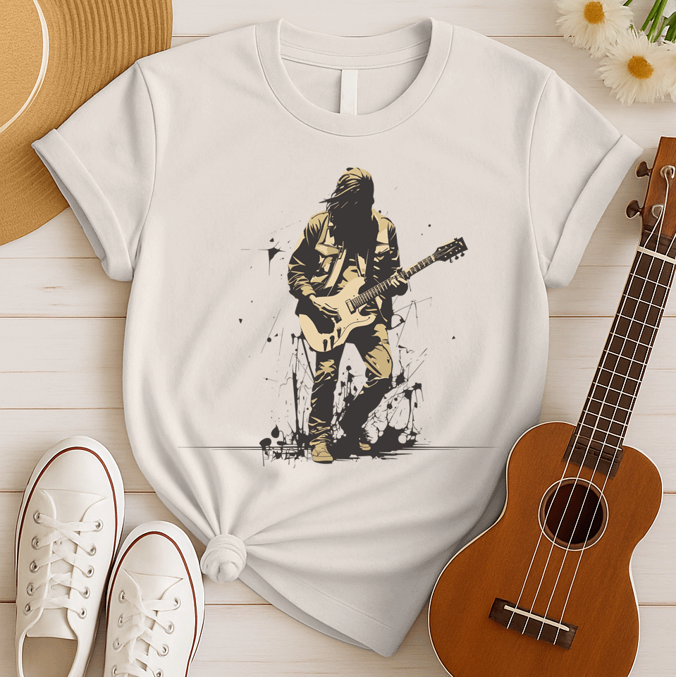 A striking graphic design depicts a silhouetted rock musician, with dark, flowing hair and a black outline, intensely playing a light beige electric guitar. The musician wears a detailed beige jacket and pants, with their form subtly highlighted against the darker background. Splatters of black paint or ink are visible around the musician's feet, adding a raw, energetic, and slightly rebellious aesthetic to the overall composition.
