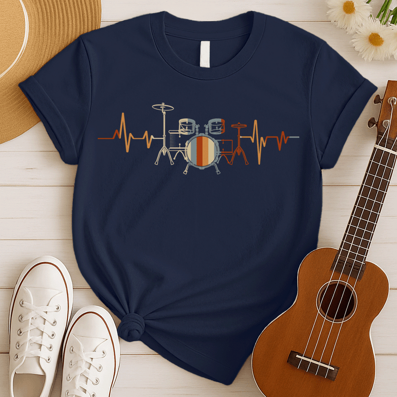 A musical graphic design features a drum kit, depicted with thin outlines, centrally positioned within a horizontal electrocardiogram (ECG) heartbeat line that pulses across the frame. The drum set and the heartbeat line are rendered in a warm, retro color palette of orange, light blue, and beige, with vertical stripes on the bass drum. This illustration beautifully merges the passion for drumming with the rhythm of life.