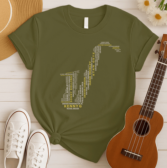 A creative typographic design forms the silhouette of a saxophone using the names of various famous jazz musicians and saxophonists. The names, in white text of varying sizes and fonts, fill the entire shape of the instrument. Prominently featured in larger, bold yellow text at the bottom is "KENNY G", with "MICHAEL BRECKER" directly below it in white, creating a visual tribute to jazz legends.