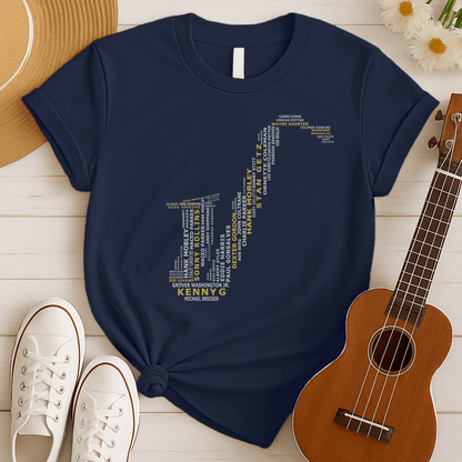 A creative typographic design forms the silhouette of a saxophone using the names of various famous jazz musicians and saxophonists. The names, in white text of varying sizes and fonts, fill the entire shape of the instrument. Prominently featured in larger, bold yellow text at the bottom is "KENNY G", with "MICHAEL BRECKER" directly below it in white, creating a visual tribute to jazz legends.