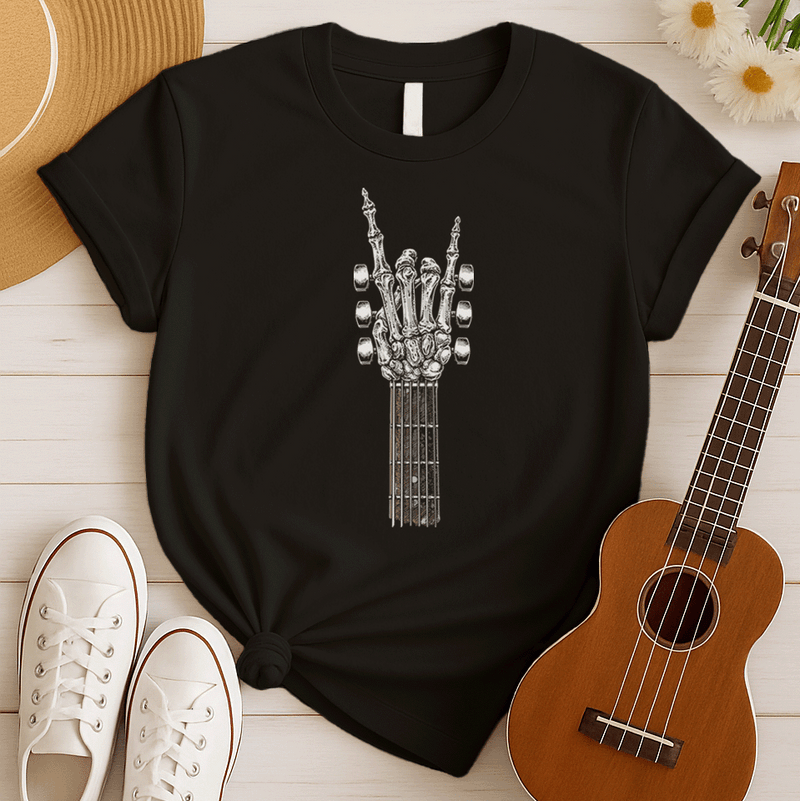 A bold graphic design depicts a skeletal hand forming the classic "rock and roll" sign, with the index and pinky fingers extended upwards, and the thumb holding down the middle two fingers. The hand, rendered in a detailed bone-like texture with shades of white and gray, is positioned at the top of a guitar fretboard, which features brown and white frets and tuning pegs on either side. This powerful image symbolizes the enduring spirit of rock music and its connection to the eternal nature of this genre.