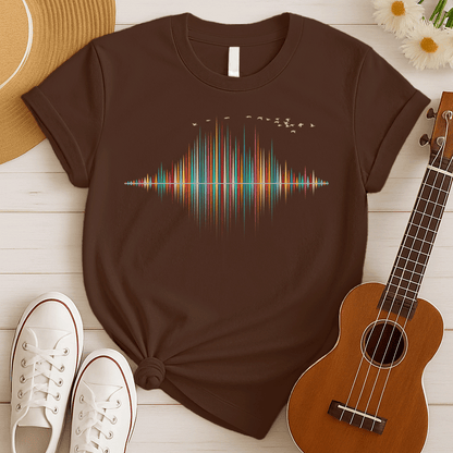 A dynamic graphic design showcases a colorful sound equalizer or sound wave, with vertical bars of varying heights in shades of red, orange, green, blue, and yellow. The bars appear to rise from and reflect into a central horizontal axis, creating a symmetrical visual representation of sound. A flock of small, light-colored birds flies in an arc across the top right of the design, adding a sense of movement. The entire vibrant composition symbolizes music, audio, or a vibrant auditory experience.