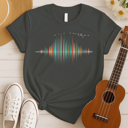 A dynamic graphic design showcases a colorful sound equalizer or sound wave, with vertical bars of varying heights in shades of red, orange, green, blue, and yellow. The bars appear to rise from and reflect into a central horizontal axis, creating a symmetrical visual representation of sound. A flock of small, light-colored birds flies in an arc across the top right of the design, adding a sense of movement. The entire vibrant composition symbolizes music, audio, or a vibrant auditory experience.