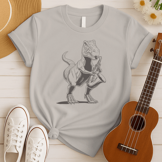 A powerful graphic design depicts a dark grey Tyrannosaurus Rex (T-Rex) holding and seemingly playing a saxophone. The T-Rex is detailed with scales and a strong posture, clutching the saxophone in its small but capable forelimbs. The musical instrument is rendered in a slightly lighter shade of grey, showcasing its keys and bell. This unique illustration, humorously blends prehistoric might with the smooth sounds of jazz or blues.