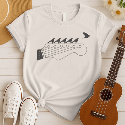 Stylized black graphic of a guitar headstock with tuning pegs and strings. Five small birds are perched in silhouette on the guitar strings, and one bird is depicted flying away in the top right corner. The design suggests musical harmony, freedom, and a connection between nature and guitar music. Ideal for guitar enthusiasts and musicians.