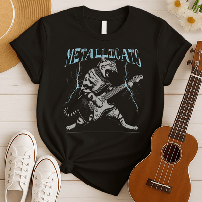 Dynamic graphic of a gray striped tabby cat with its mouth open, appearing to roar, passionately playing a black and white electric guitar. Blue lightning bolts emanate from the guitar. Text above reads "METALLICATS". The cat wears a studded collar. Ideal for heavy metal fans, rock music lovers, guitarists, and cat lovers.