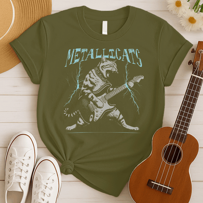 Dynamic graphic of a gray striped tabby cat with its mouth open, appearing to roar, passionately playing a black and white electric guitar. Blue lightning bolts emanate from the guitar. Text above reads "METALLICATS". The cat wears a studded collar. Ideal for heavy metal fans, rock music lovers, guitarists, and cat lovers.