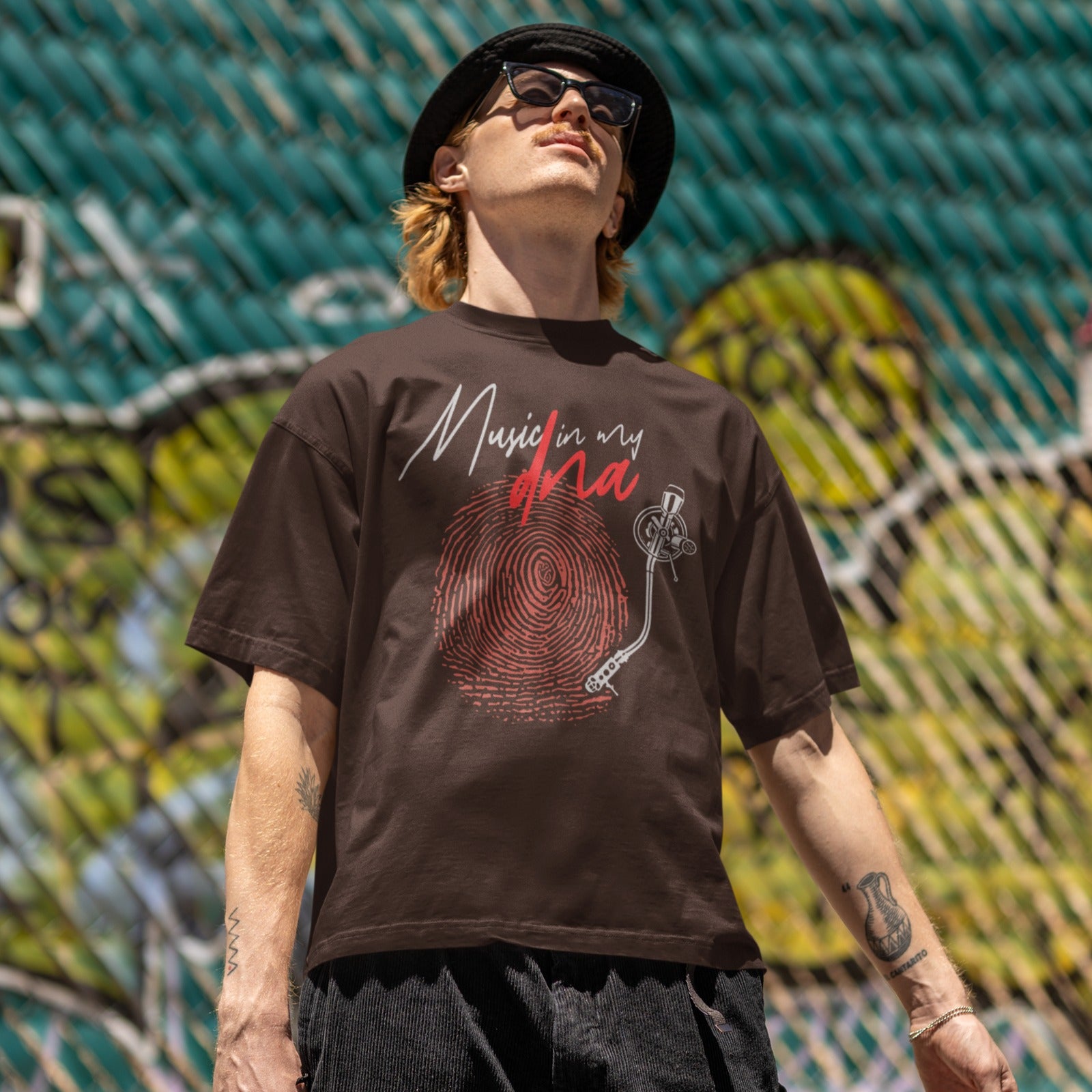 Stylized graphic of a large red fingerprint that is designed like the grooves of a vinyl record, with a white turntable tonearm and needle positioned on it. Above, white handwritten text says "Music in my" and red stylized text says "dna". The design perfectly symbolizes an inherent passion for music, vinyl records, and unique identity, ideal for music lovers and DJs.