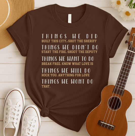 A black background features multiple lines of text in a distressed, bold font. The main headings are "THINGS WE DID," "THINGS WE DIDN'T DO," "THINGS WE WANT TO DO," "THINGS WE WILL DO," and "THINGS WE WONT DO". Underneath each heading, famous song lyrics or titles are listed, such as "BUILT THIS CITY," "SHOT THE SHERIFF," "START THE FIRE," "BREAK FREE," "ROCK YOU," and "ANYTHING FOR LOVE". The overall design is a tribute to iconic rock music, song lyrics, and music history, ideal for classic rock fans and m