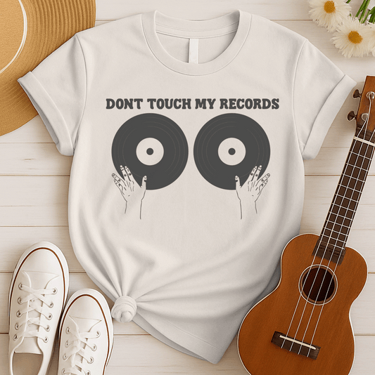 A black background features the bold, capitalized text "DONT TOUCH MY RECORDS" at the top. Below, two large, dark grey vinyl records are depicted side-by-side, with two outlined hands reaching up from the bottom, appearing to cup or touch the records. The design is humorous, symbolizing a possessive love for music, vinyl records, and record collecting, ideal for audiophiles and music fans.
