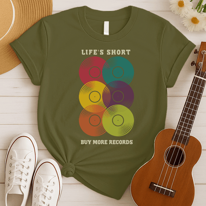 A black background features six vertically stacked, colorful vinyl records (LP records) with visible grooves and black center labels. The record colors include red, teal, yellow, purple, orange, and green. At the top, the distressed text "LIFE'S SHORT" is present, and at the bottom, the distressed text "BUY MORE RECORDS" is visible. The design is a clear celebration of vinyl culture and music collecting.