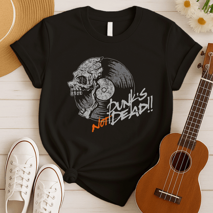 A black background features a stylized illustration of a grey human skull with a crack on its forehead, fused with a vinyl record. The record's grooves and central light grey area are visible. To the right, the distressed grey text reads "Punk's", followed by distressed white text "Not Dead!!". Below this, the orange distressed text "NOT DEAD!!" provides emphasis. The design combines punk music themes with skull imagery and vinyl records.